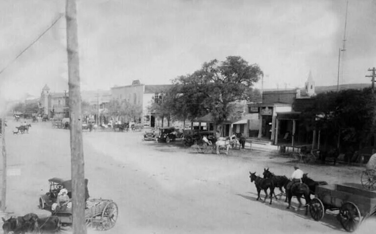 Wagons, mule teams and early automobiles on Main Street in Fredericksburg, Texas, 1915