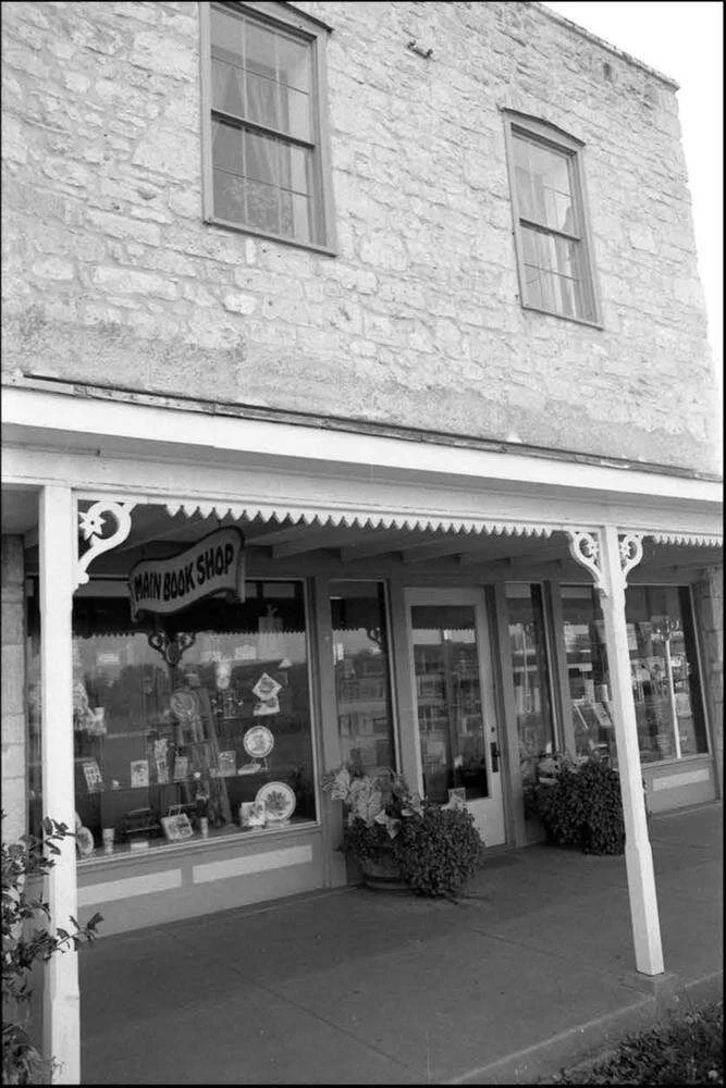 Main Book Shop storefront under the porch of the limestone Maier Building on Main Street in Fredericksburg
